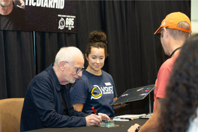Ian McDiarmid signing autographs for fans.